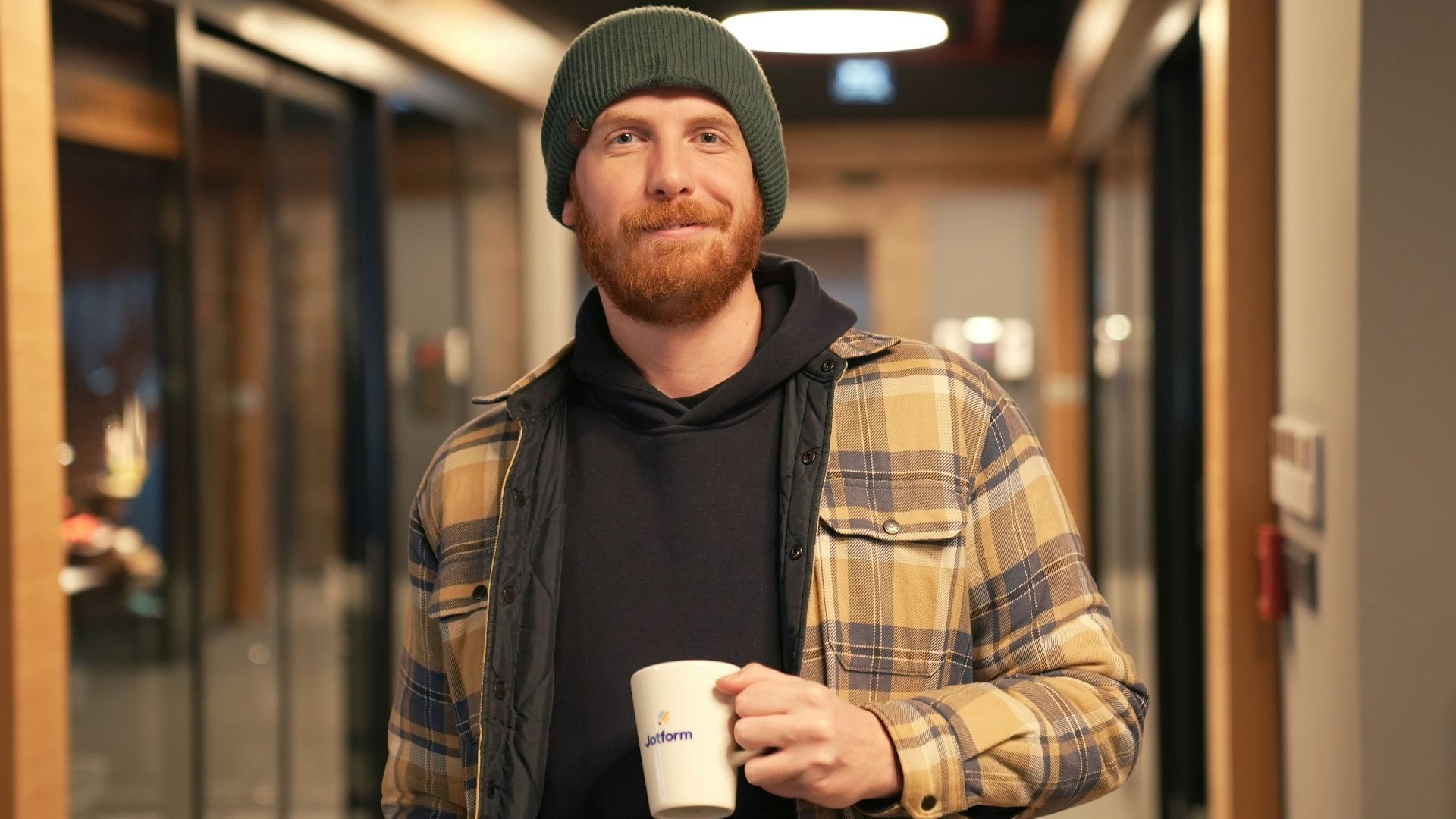 a man with a beard holding a cup of coffee