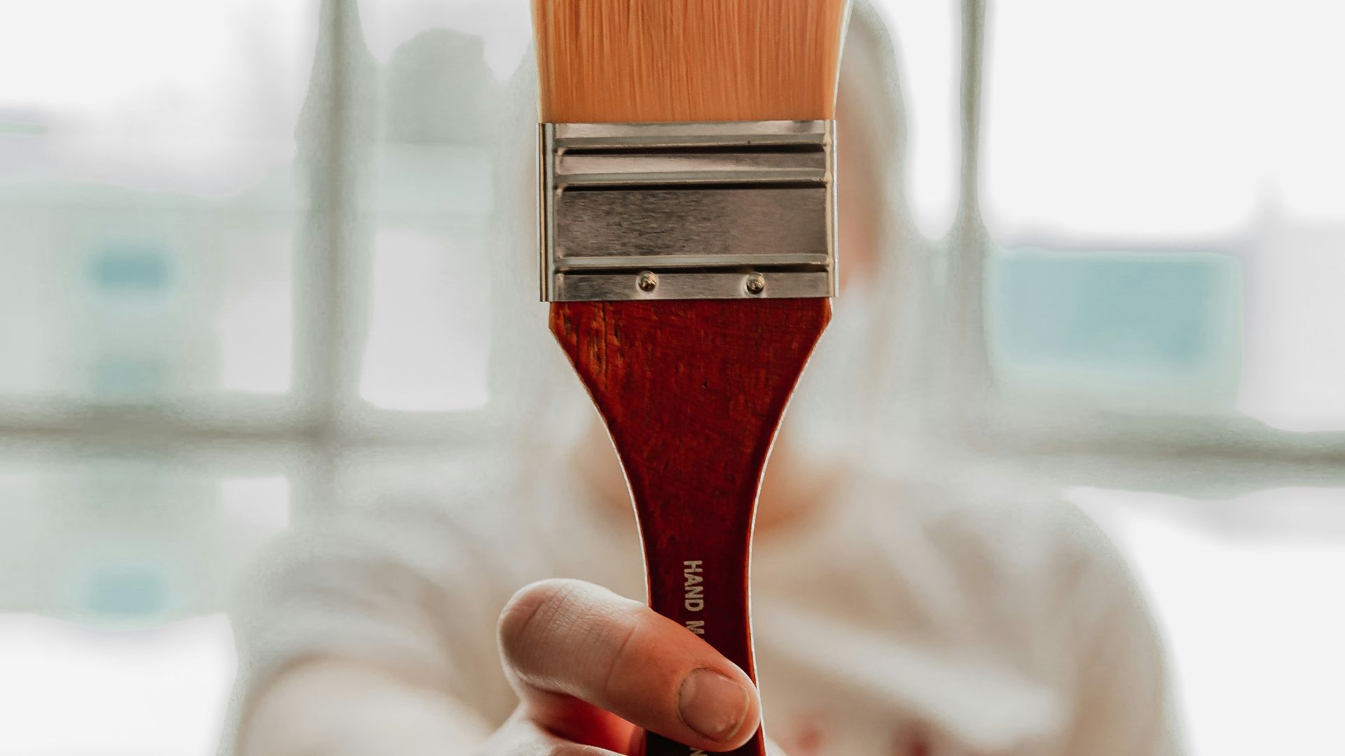 a woman holding a paint brush in her hand