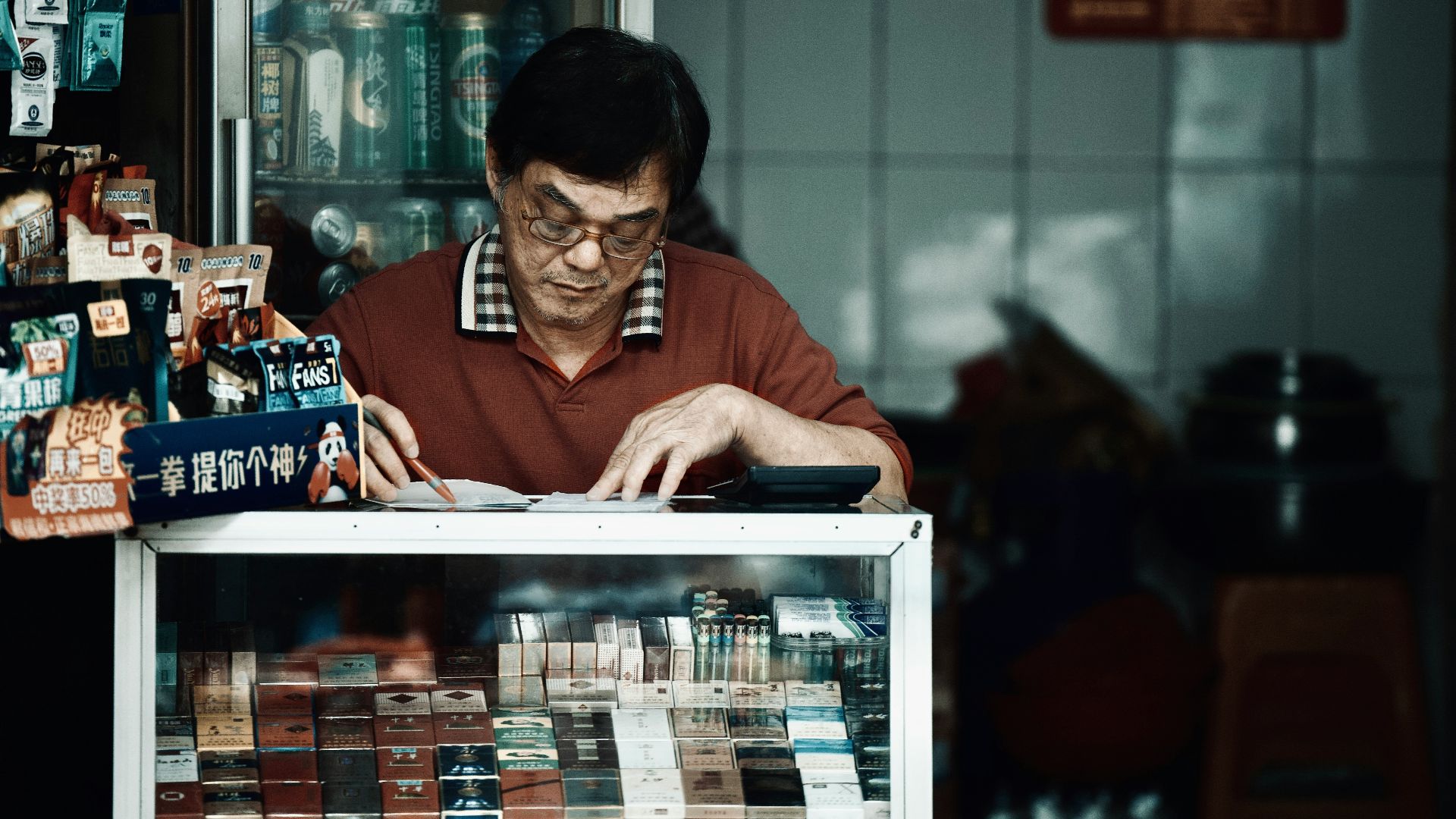 a man sitting at a table looking at a book