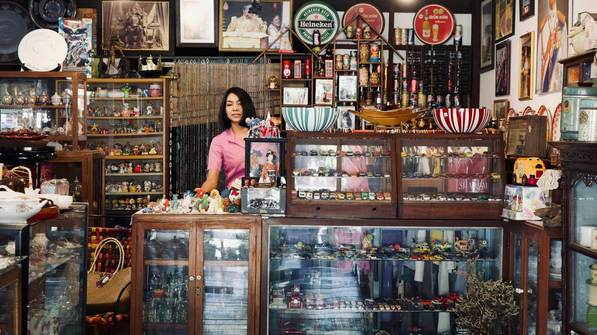 A woman standing in front of a store filled with items