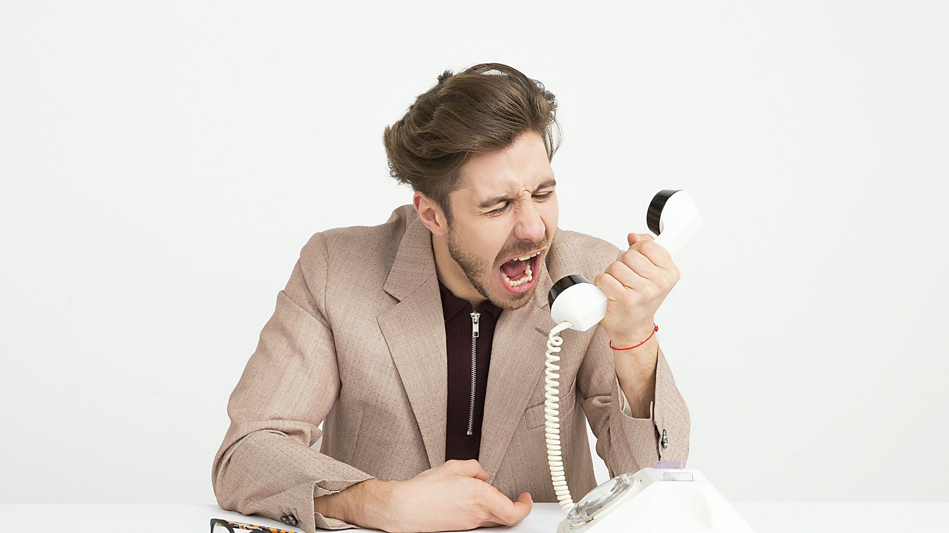 man holding telephone screaming