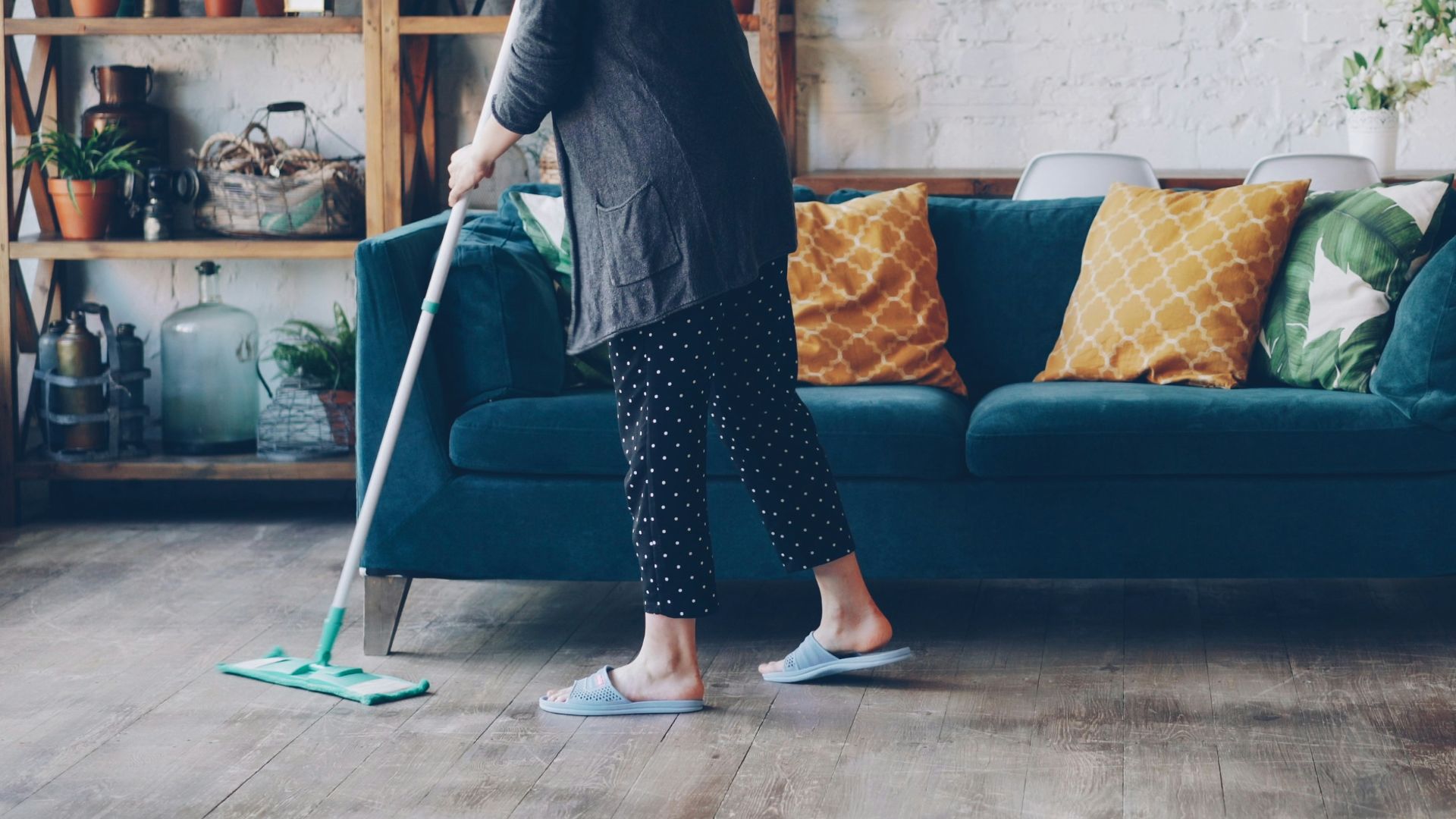 Woman cleaning the floor in a modern living room.