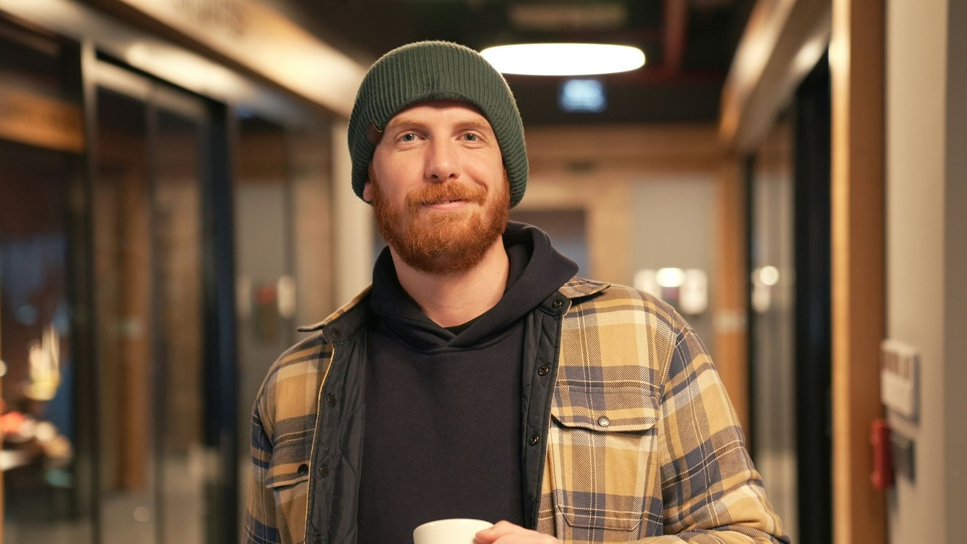 a man with a beard holding a cup of coffee