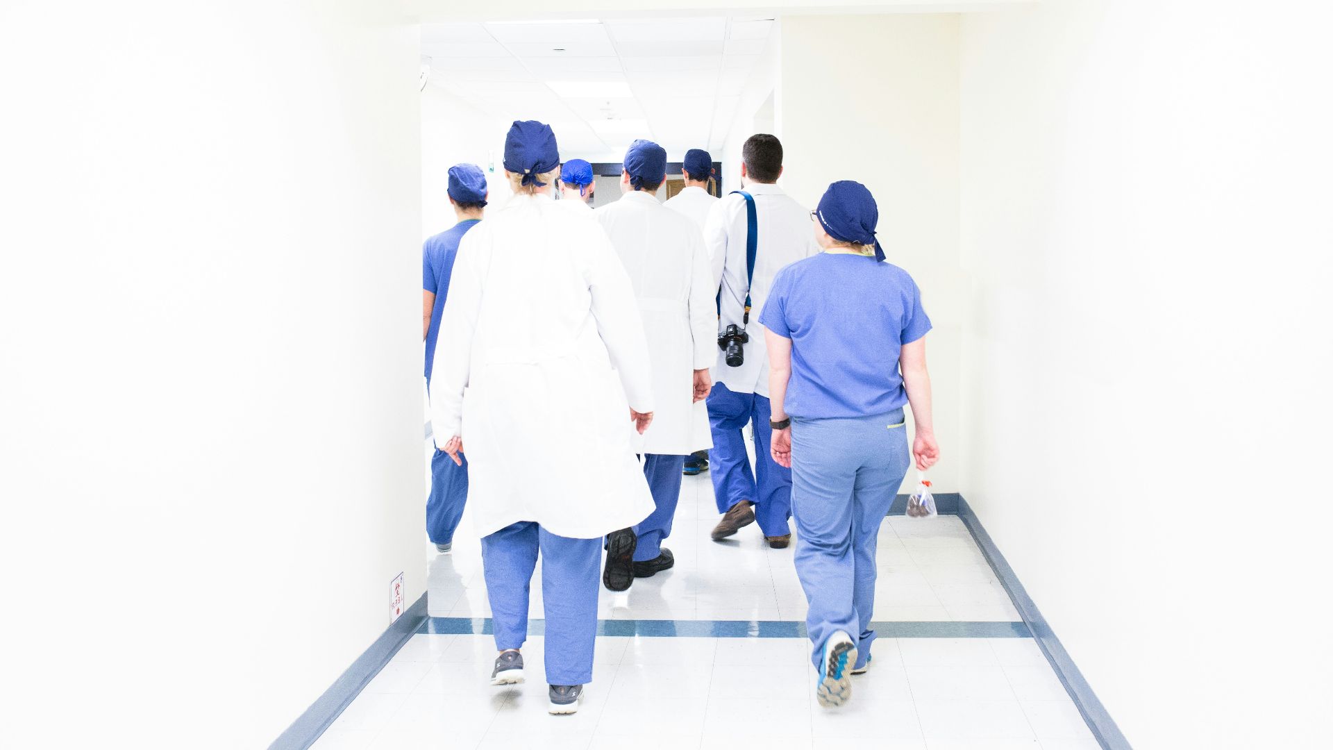 group of doctors walking on hospital hallway
