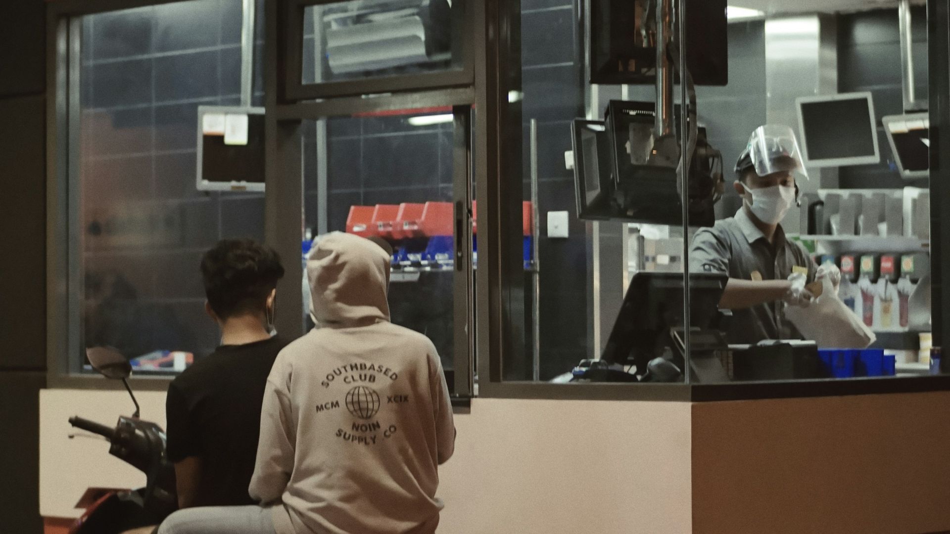 man in white shirt sitting on red and black motorcycle