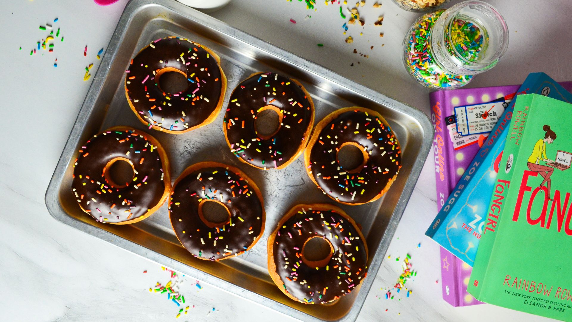 a tray of doughnuts with chocolate frosting and sprinkles