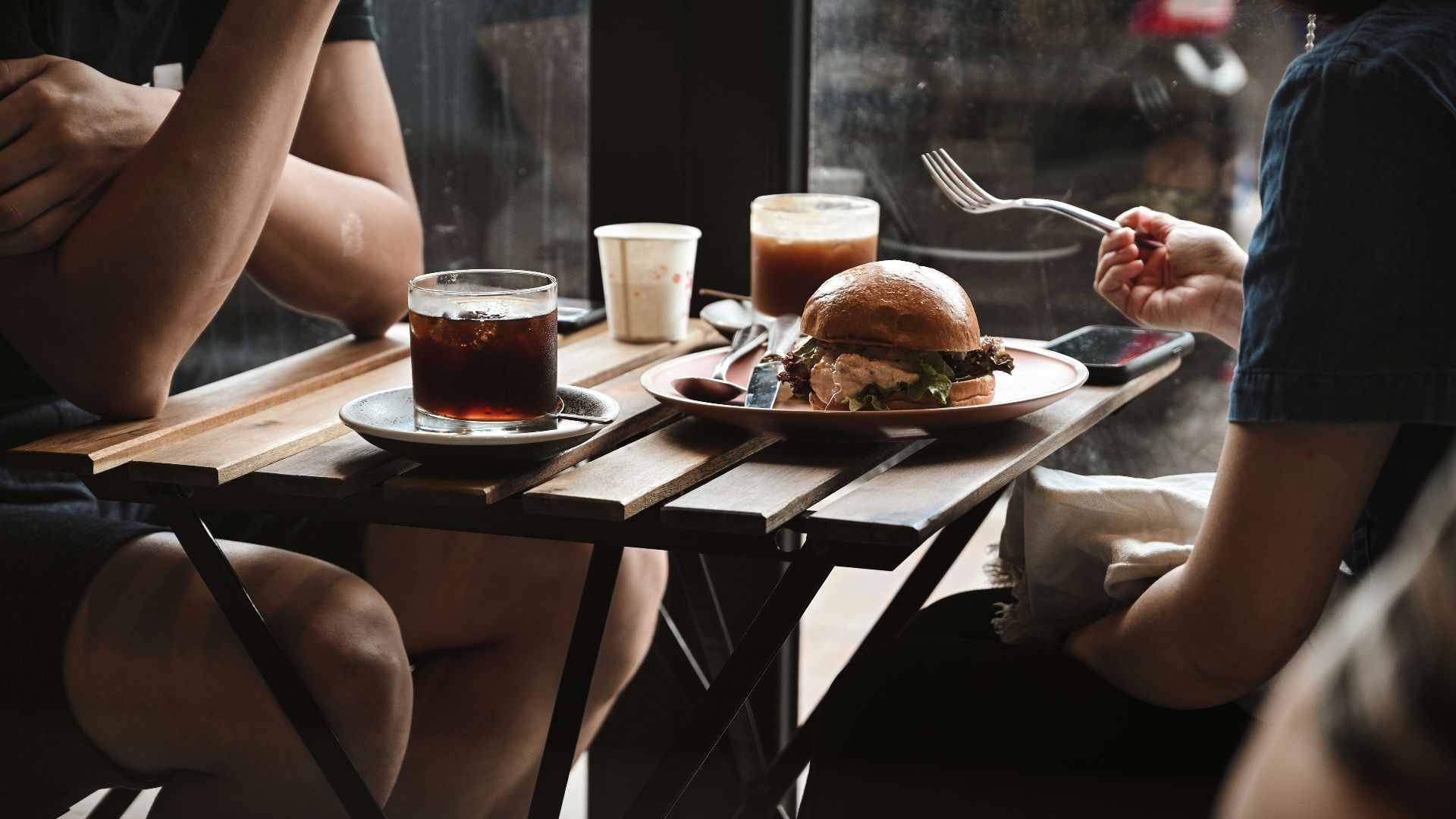 person holding stainless steel fork and bread knife