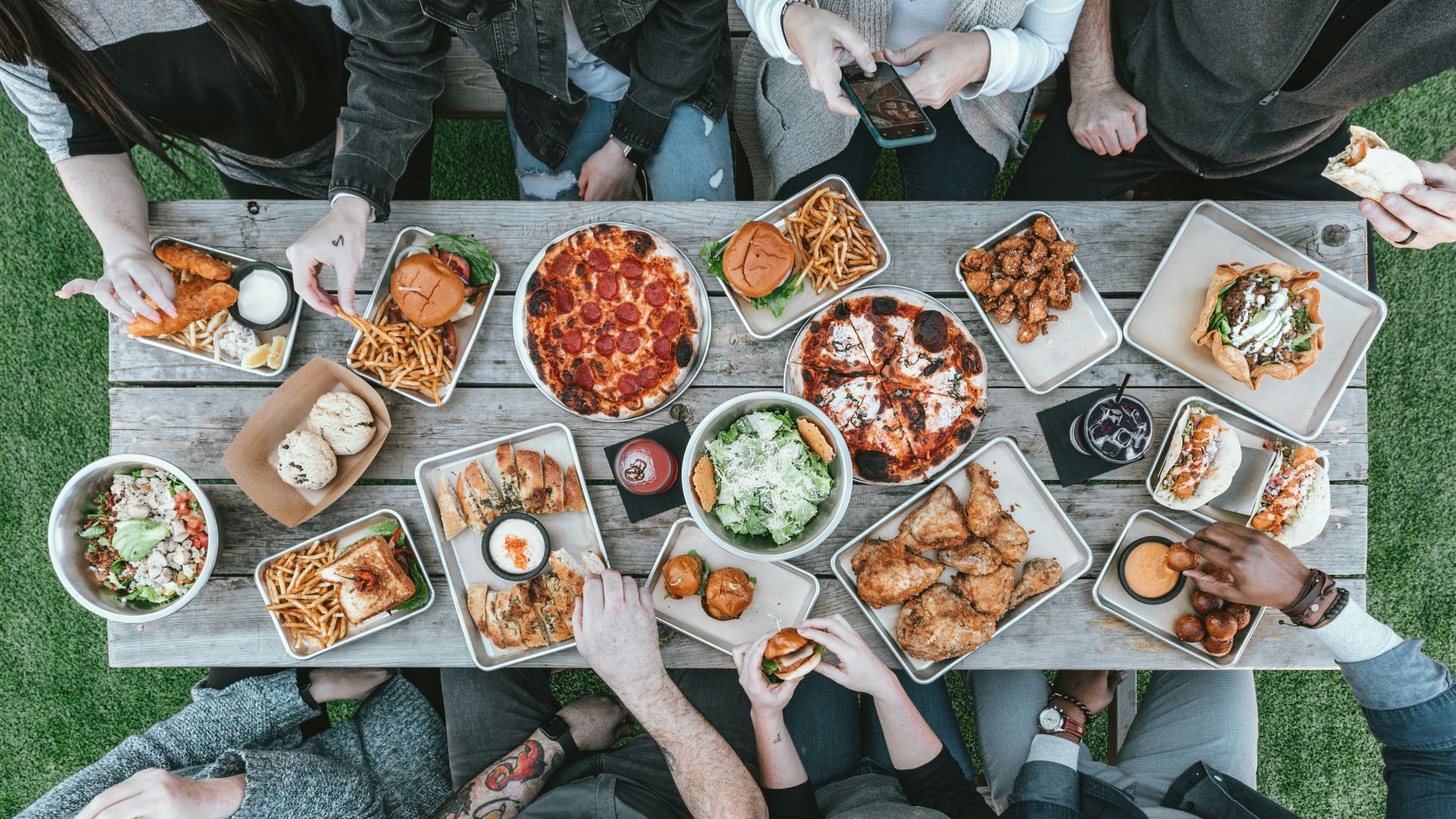 a group of people sitting around a table with food