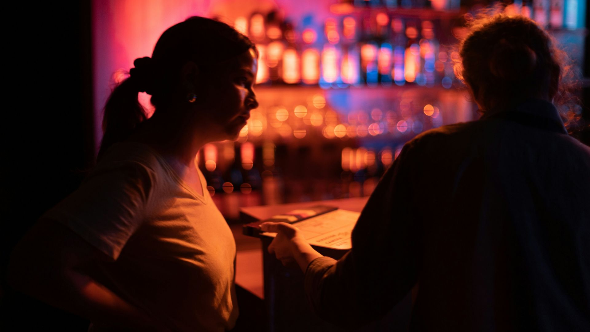 a man and woman sitting at a bar