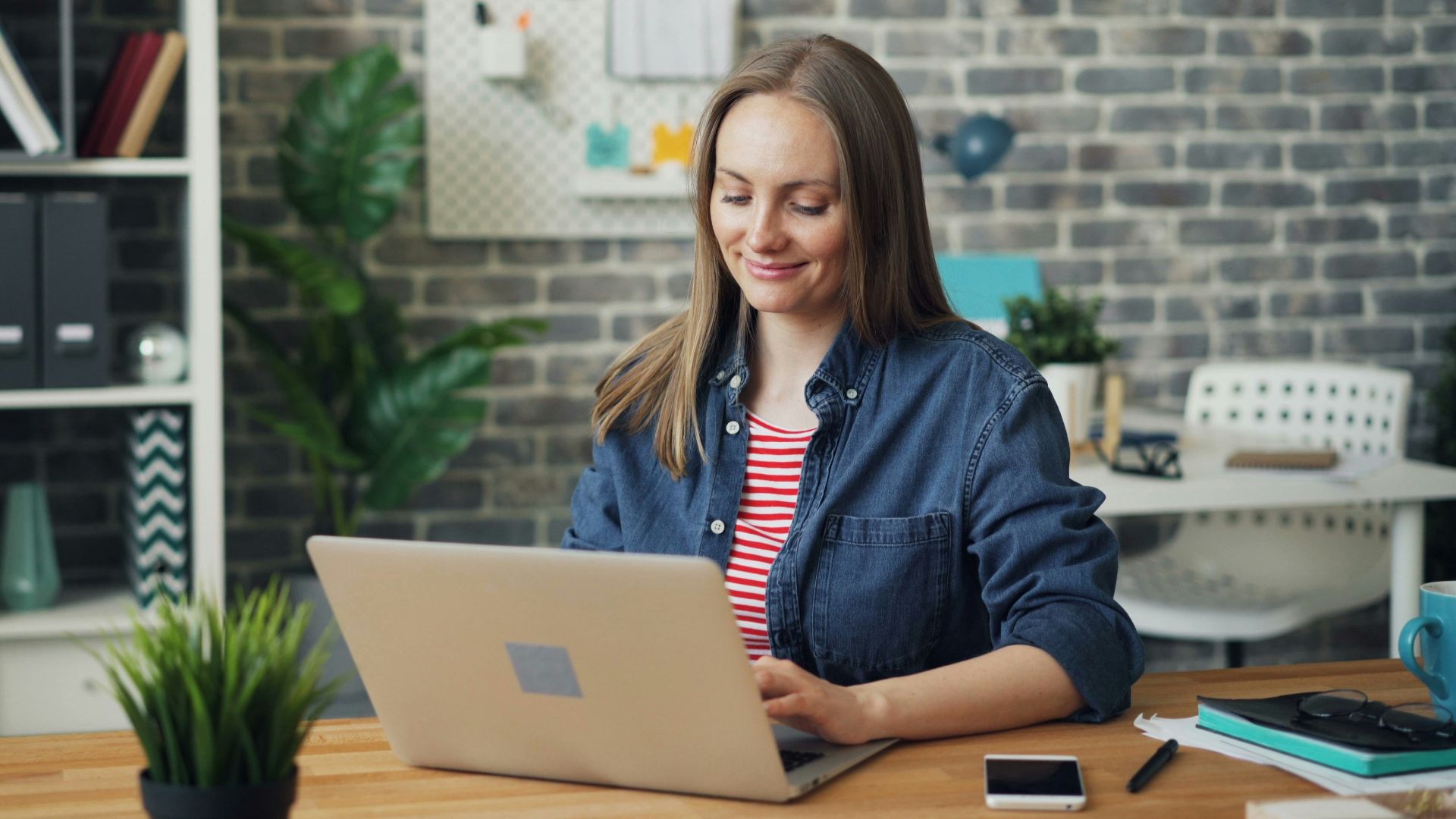 a woman sitting at a desk using a laptop computer