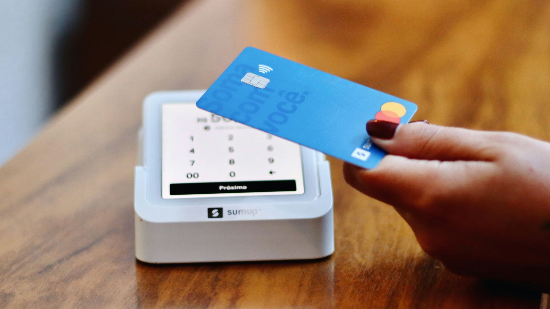 a person holding a credit card in front of a machine