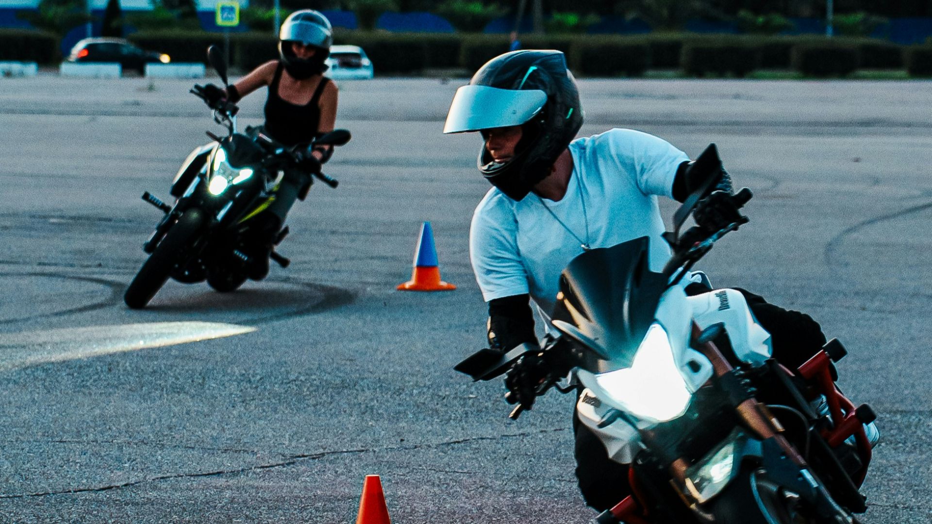 Two motorcyclists practicing on a cone course