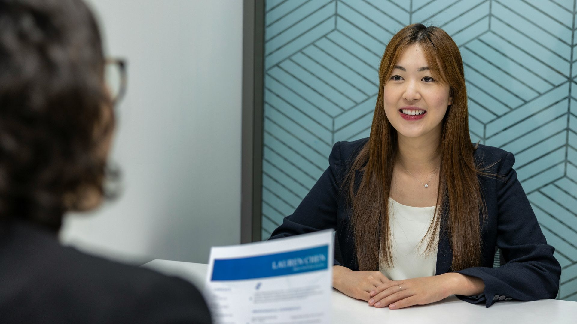 a woman sitting at a table with a piece of paper in front of her