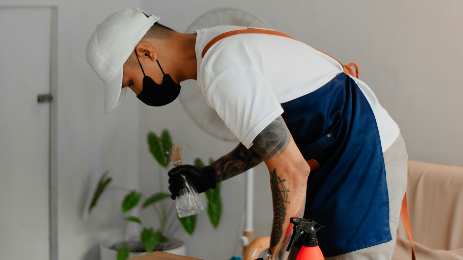 a man in an apron is sanding a wooden table