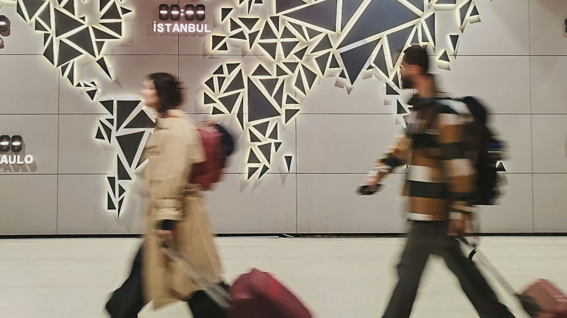 People walk past a glowing world map.