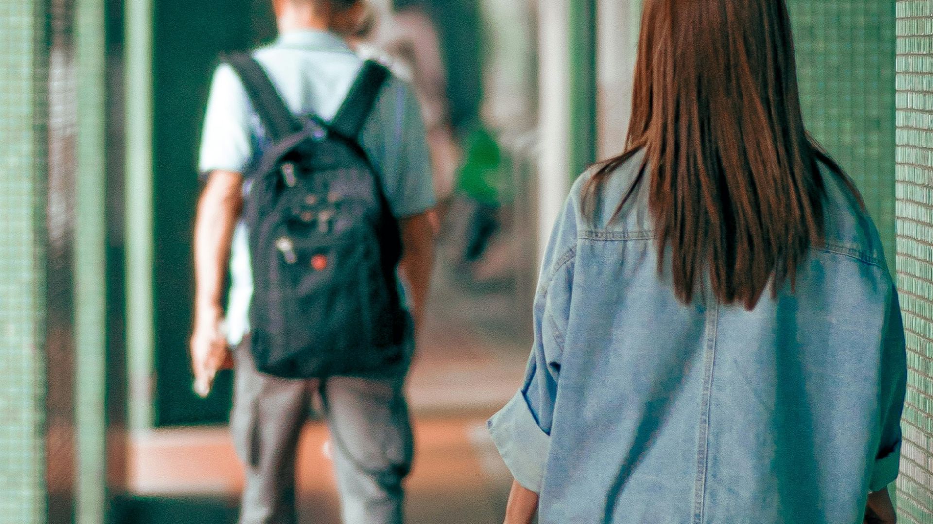 a couple of people walking down a hallway