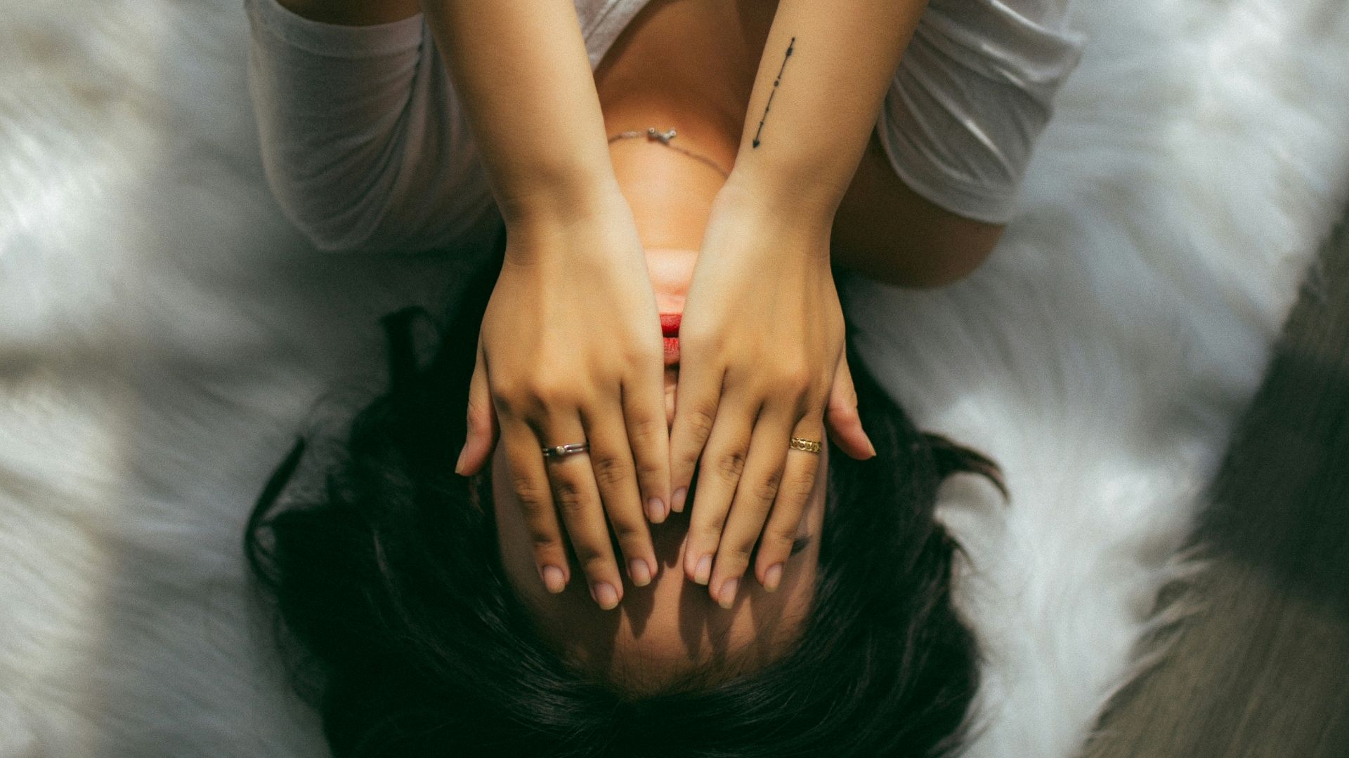 a woman holds her hands over her face