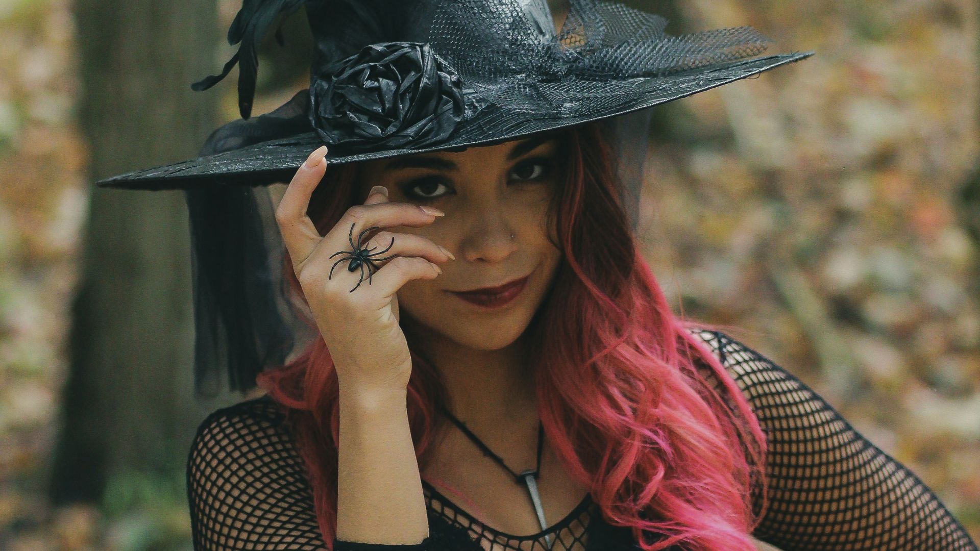 a woman with red hair wearing a witches hat