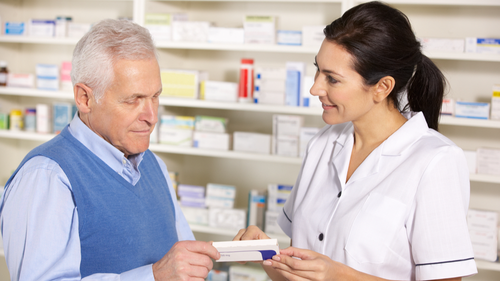 Pharmacist serving senior man in pharmacy