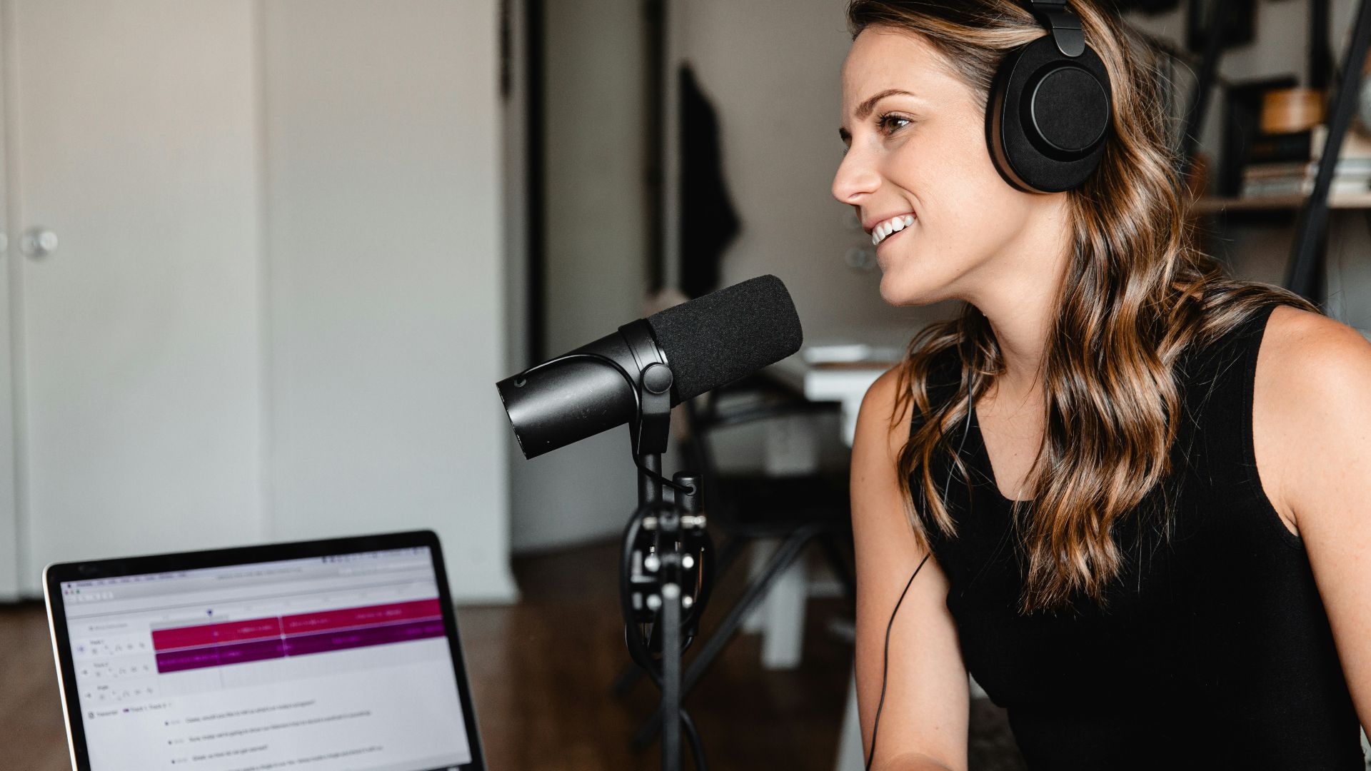woman in black tank top sitting on chair in front of microphone