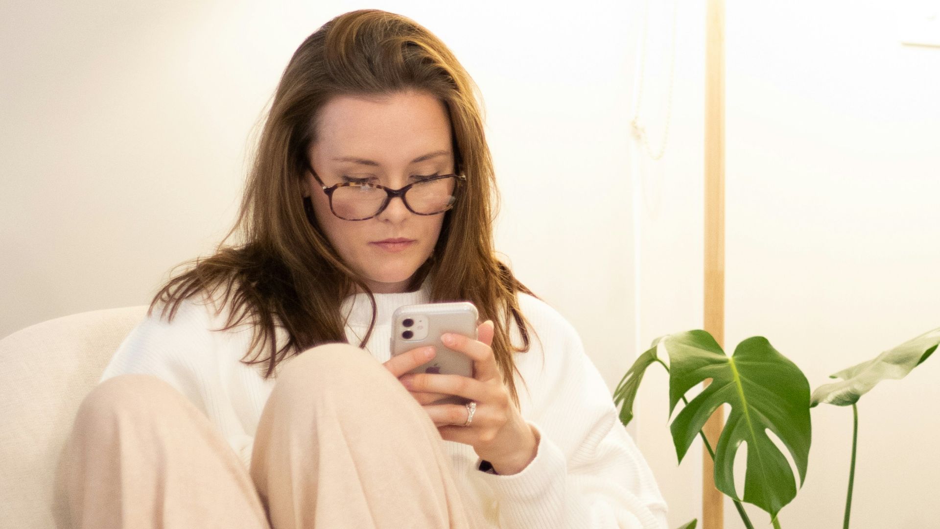 a woman sitting in a chair holding a cell phone