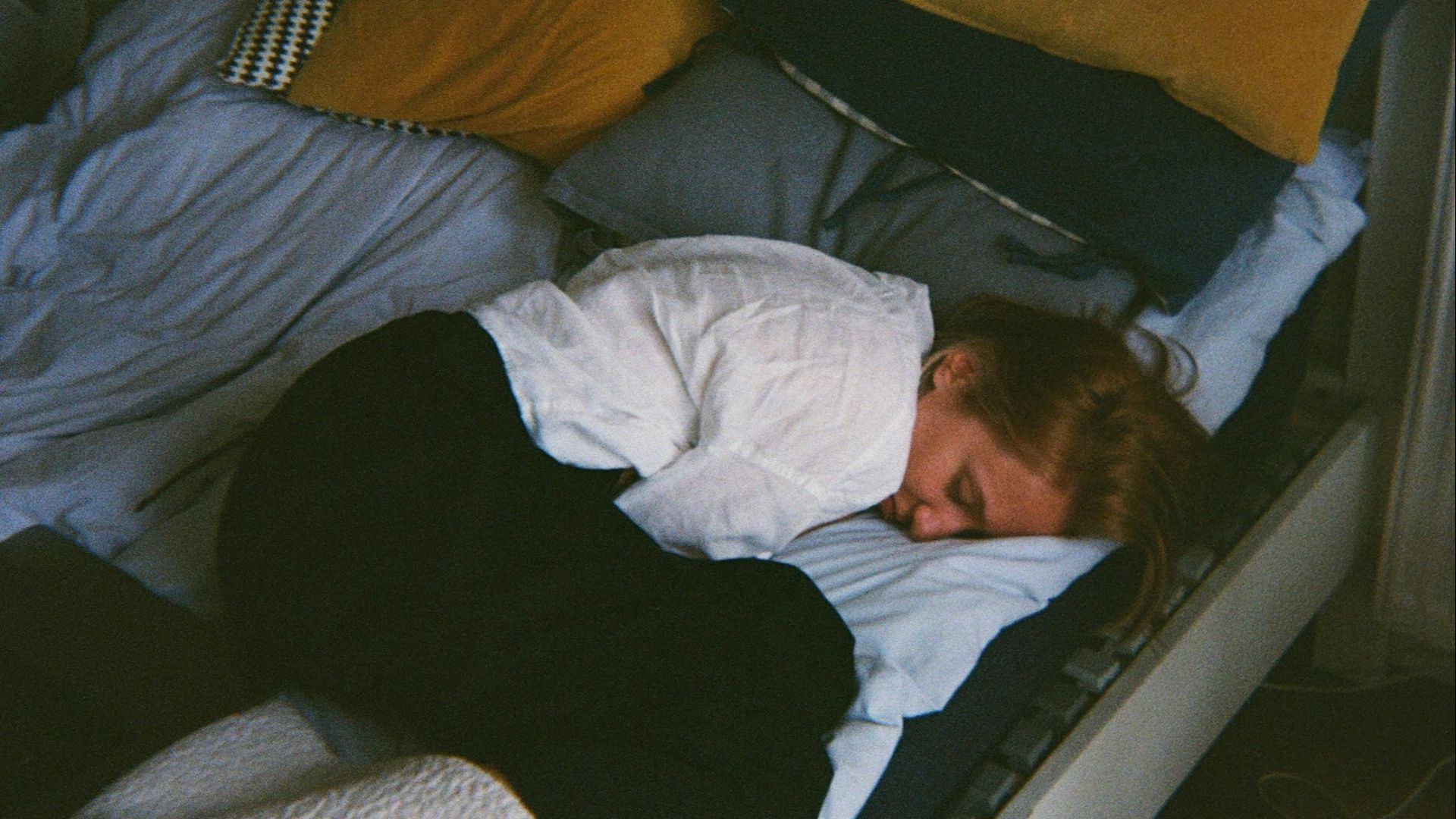 a person laying on a bed with a blanket