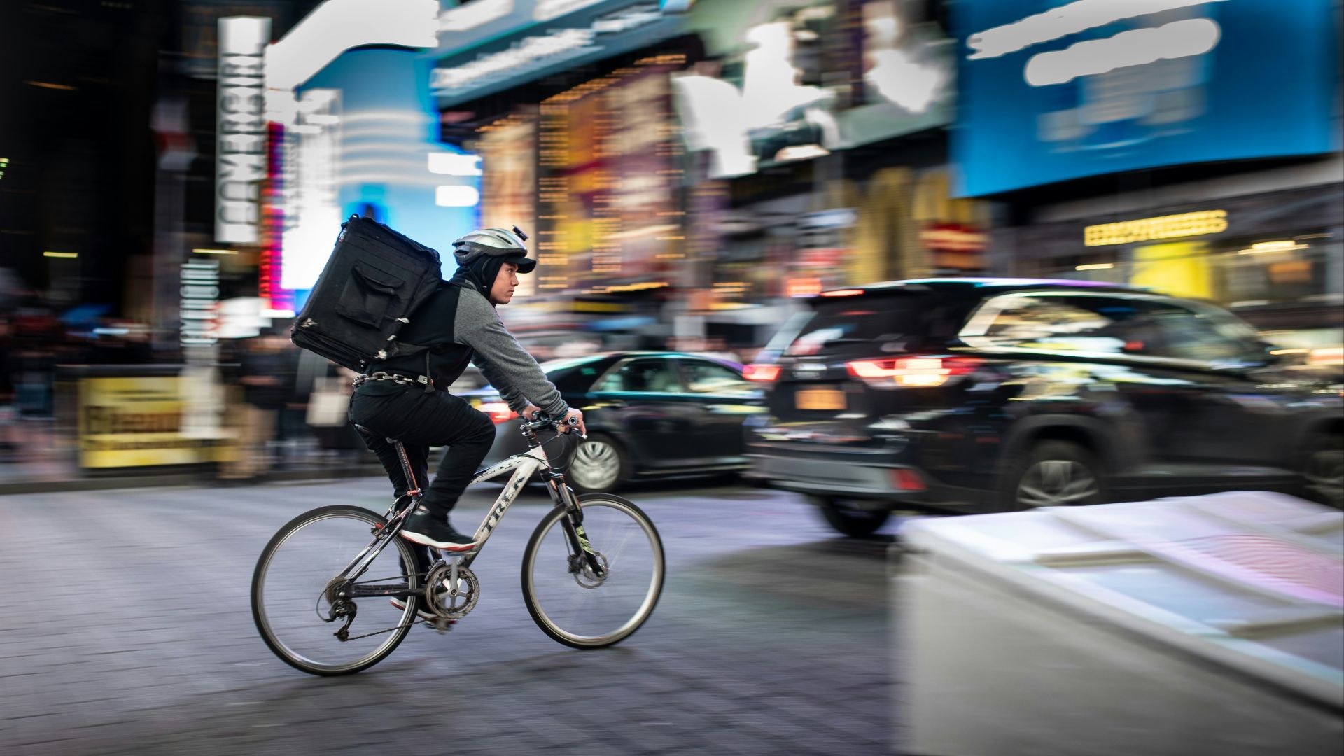 man riding bicycle near vehicles