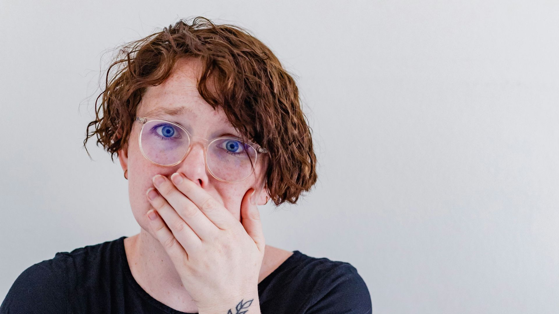 a woman covers her mouth with her hands