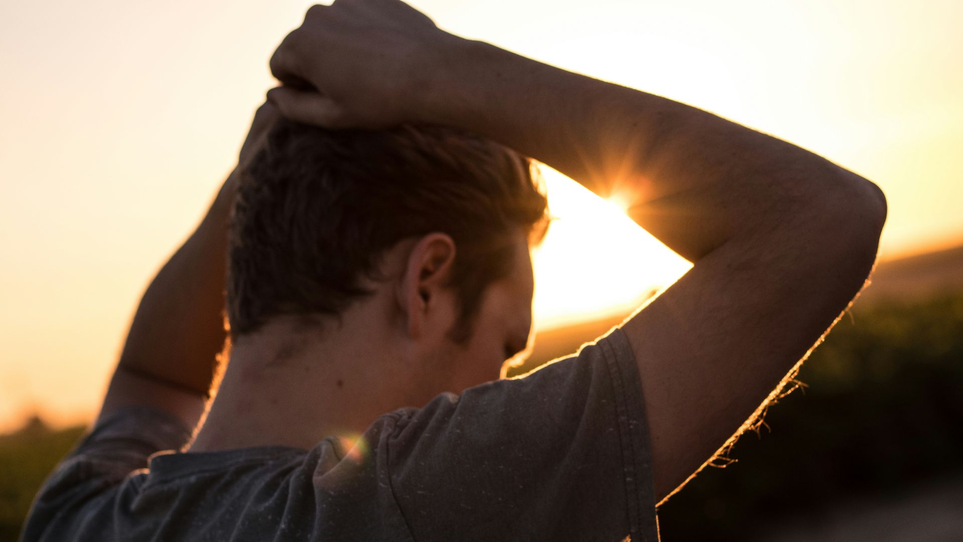 man holding his hair against sunlight