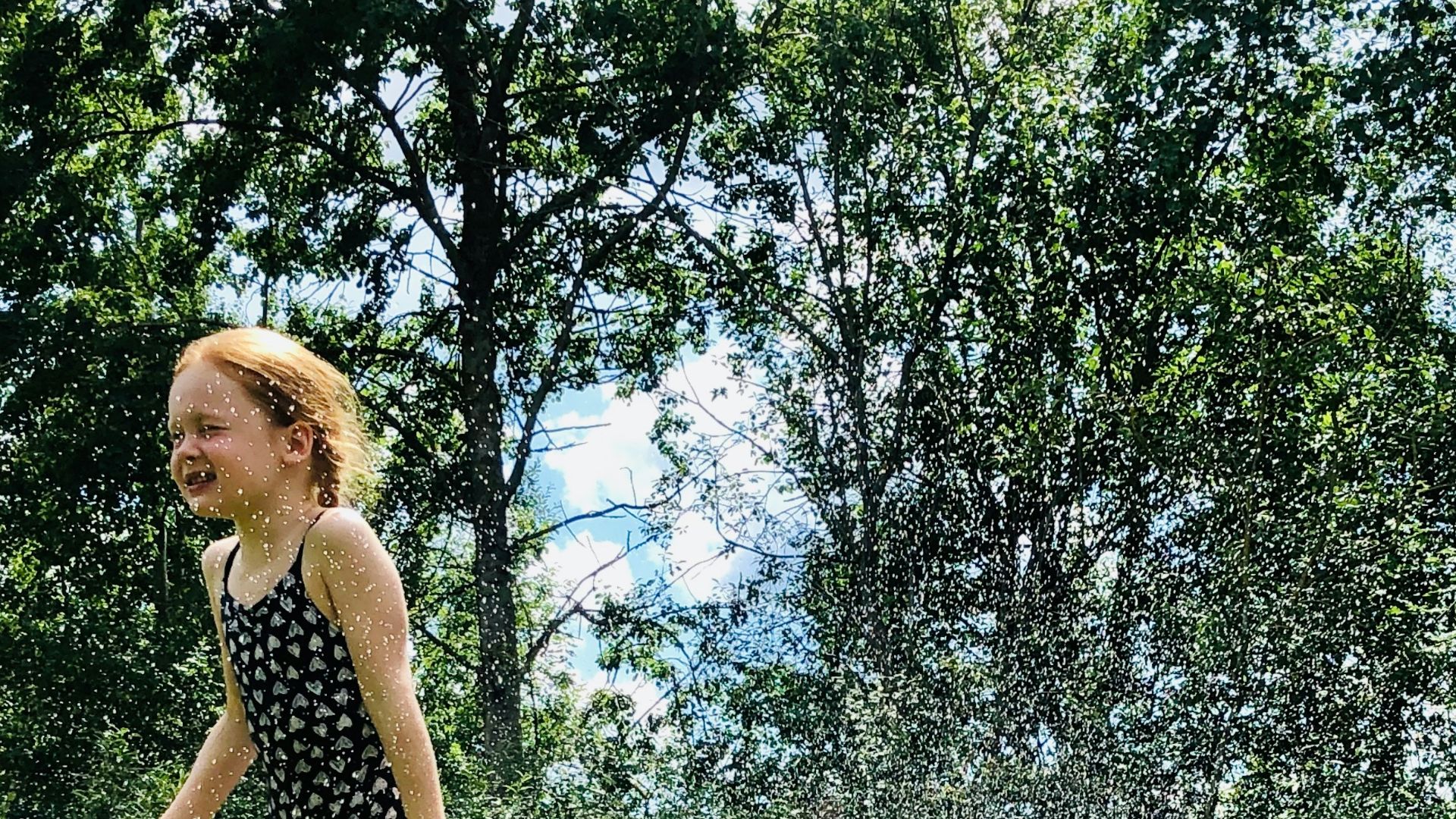 woman in black tank top and black shorts standing on green grass field during daytime