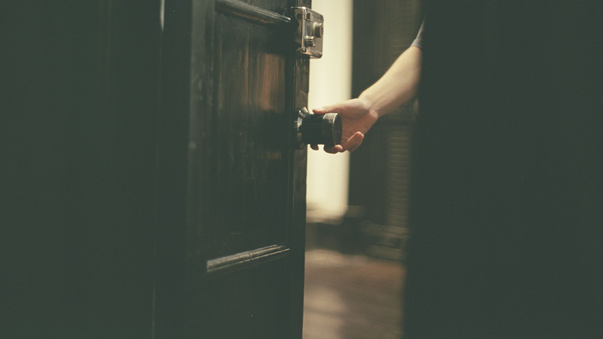 a person opening a door with their hand