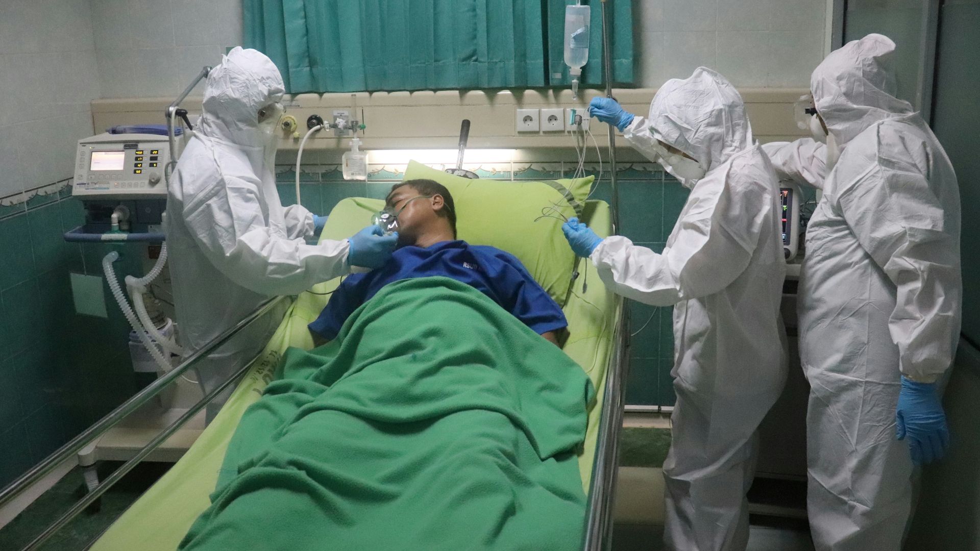 man in white scrub suit lying on hospital bed