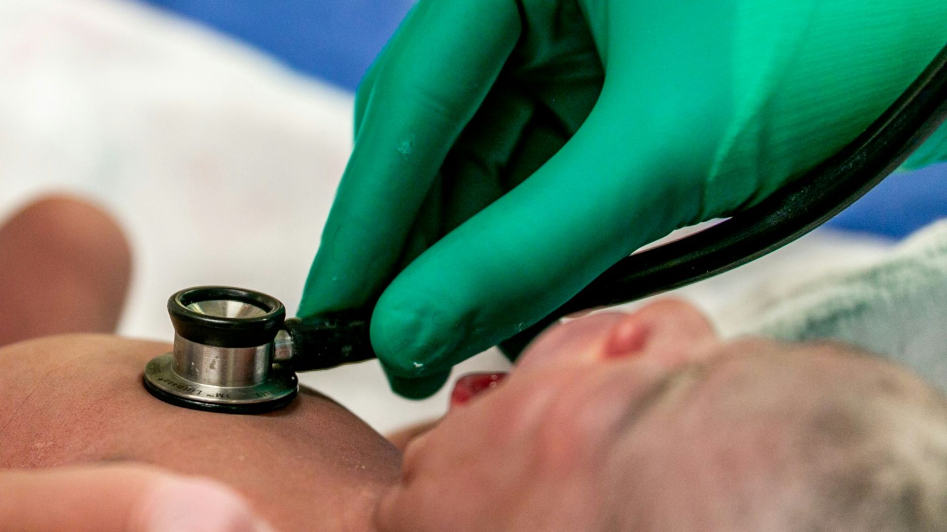 person in teal long sleeve shirt lying on bed