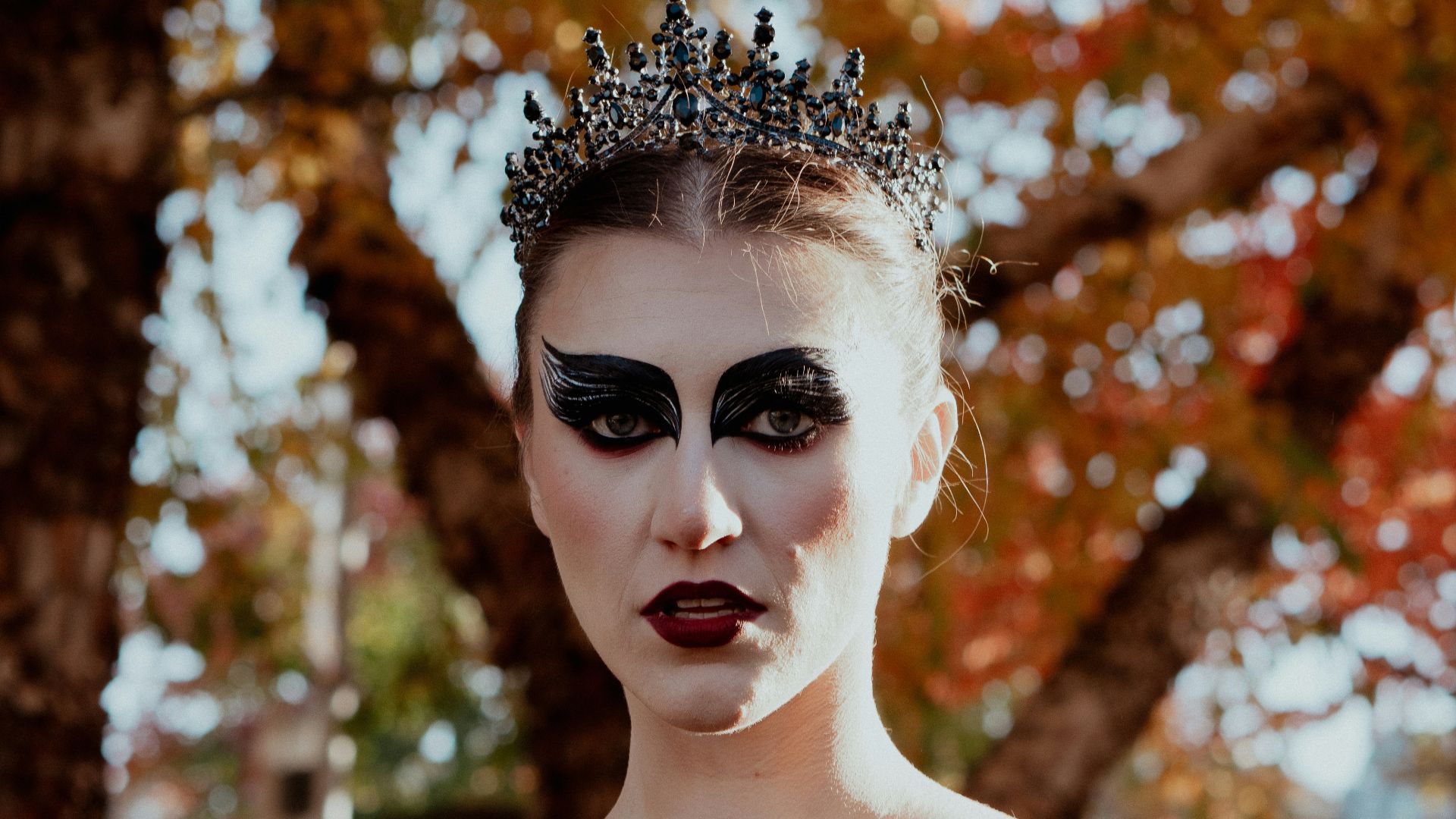 a woman in a black dress with a crown on her head
