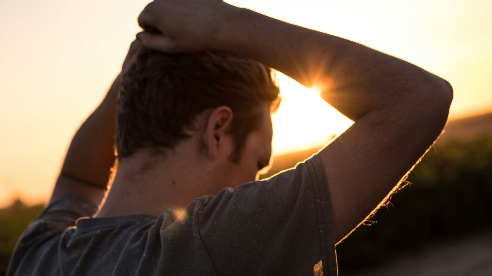 man holding his hair against sunlight