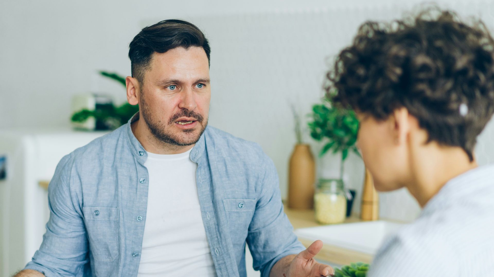 a man sitting at a table talking to a woman
