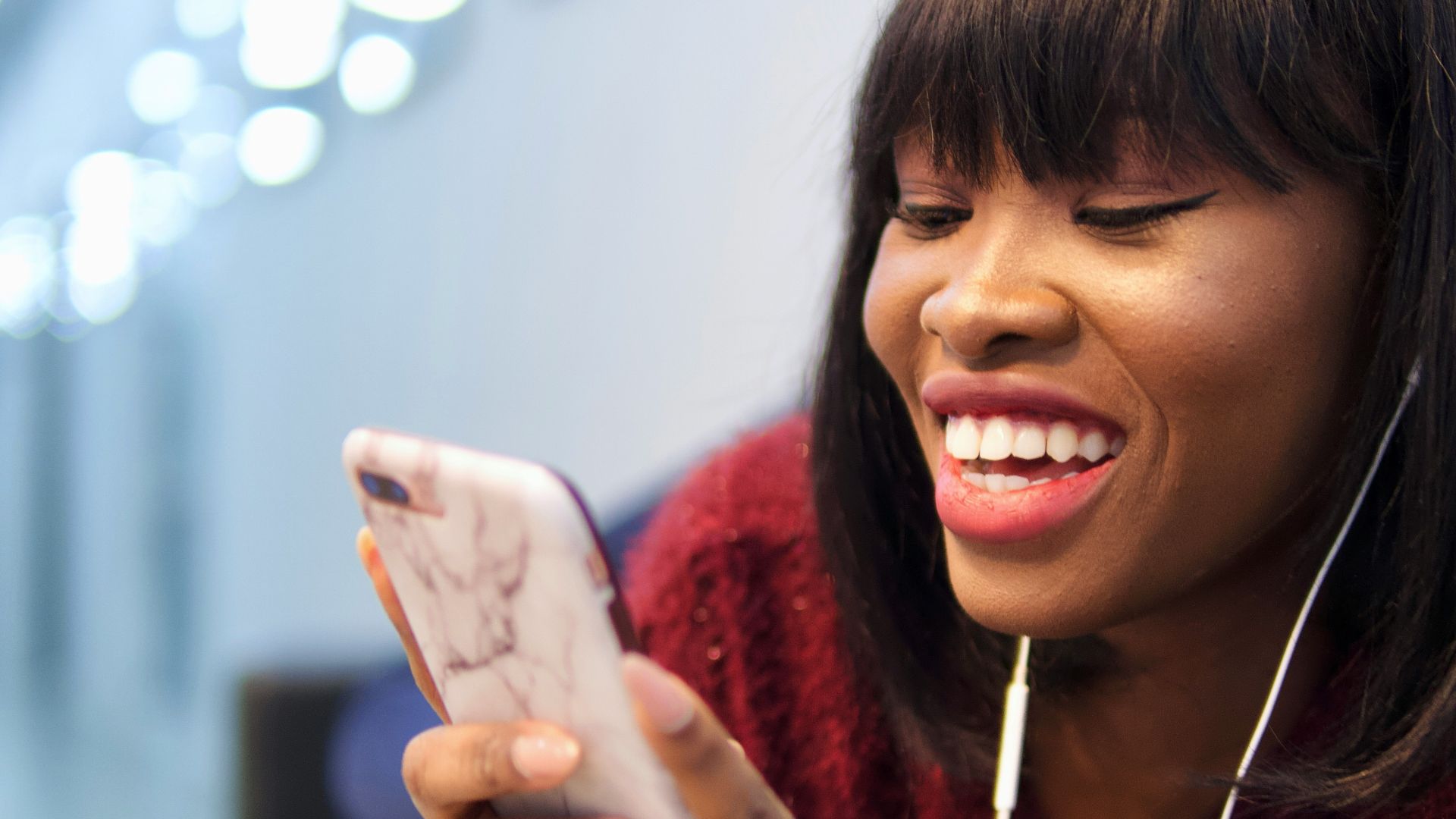 woman in pink shirt holding white smartphone