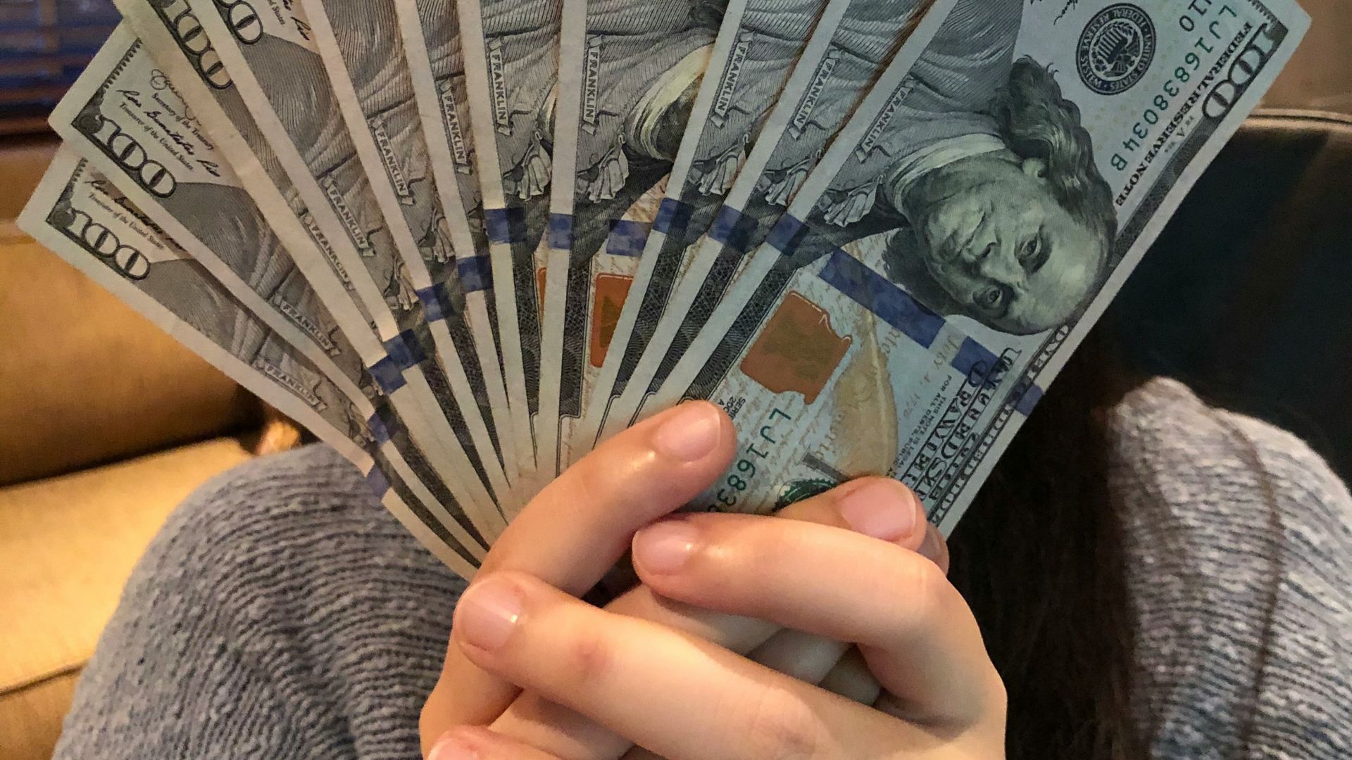 person holding fan of us dollar bill