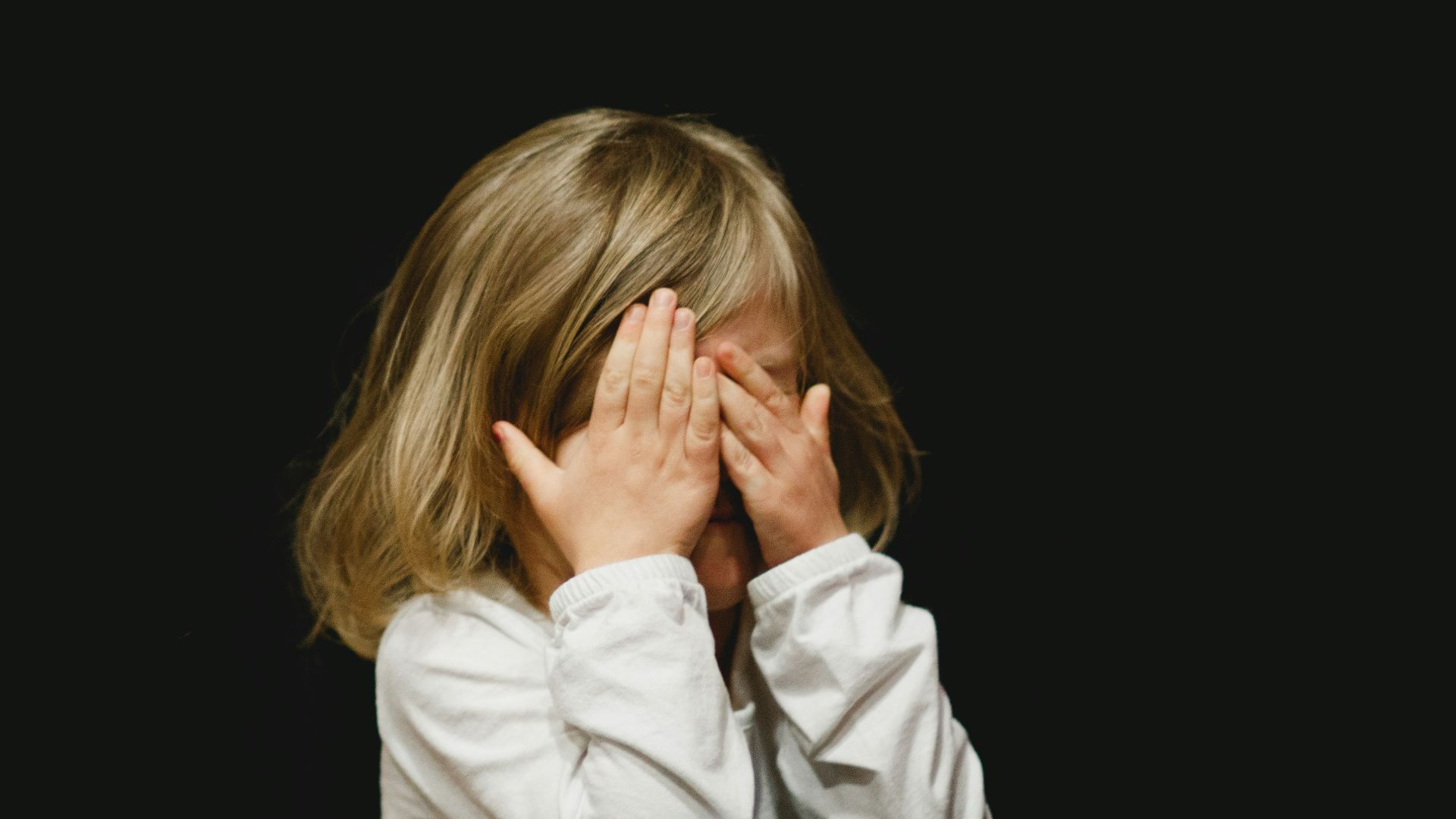 girl covering her face with both hands