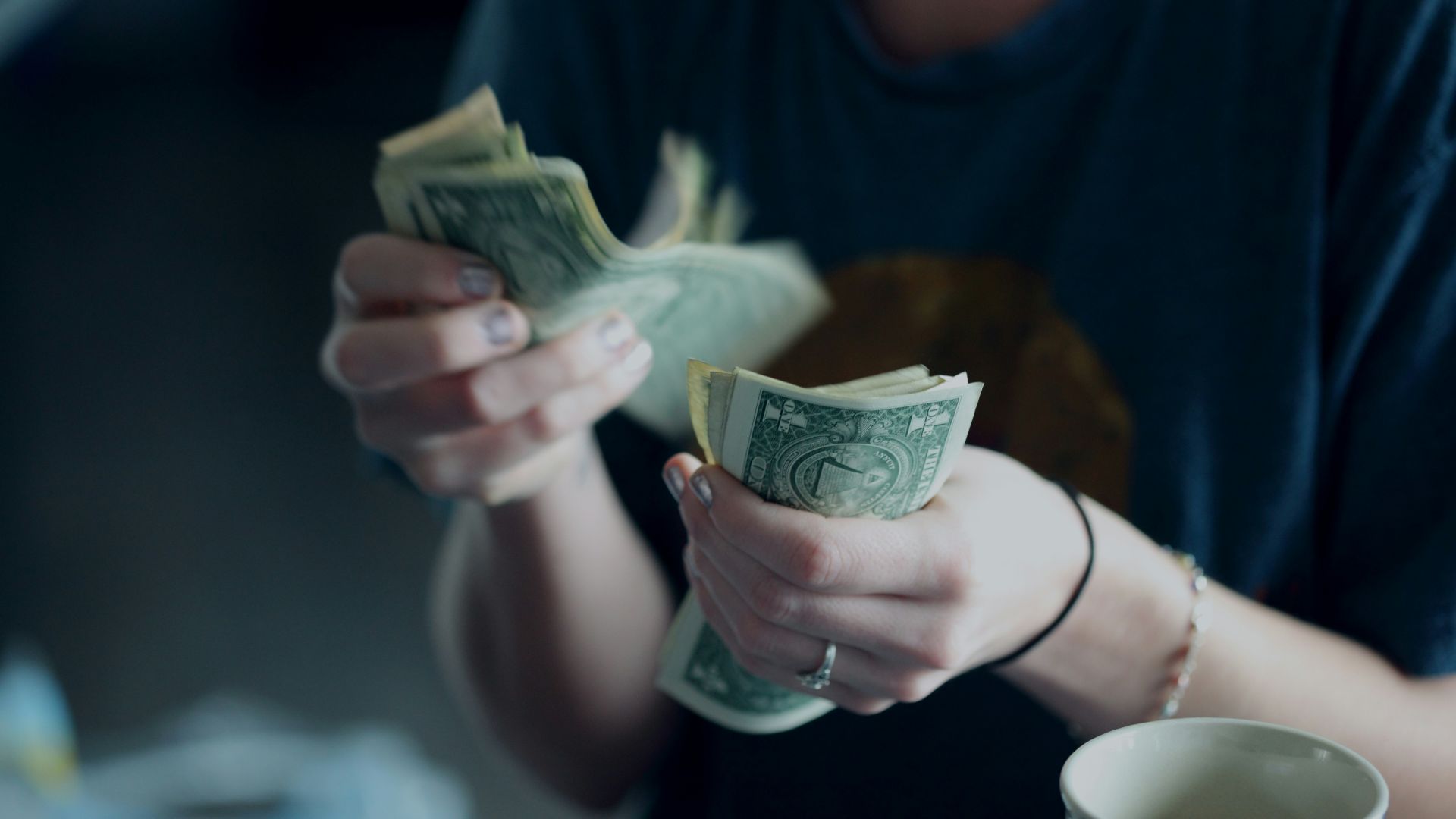 focus photography of person counting dollar banknotes