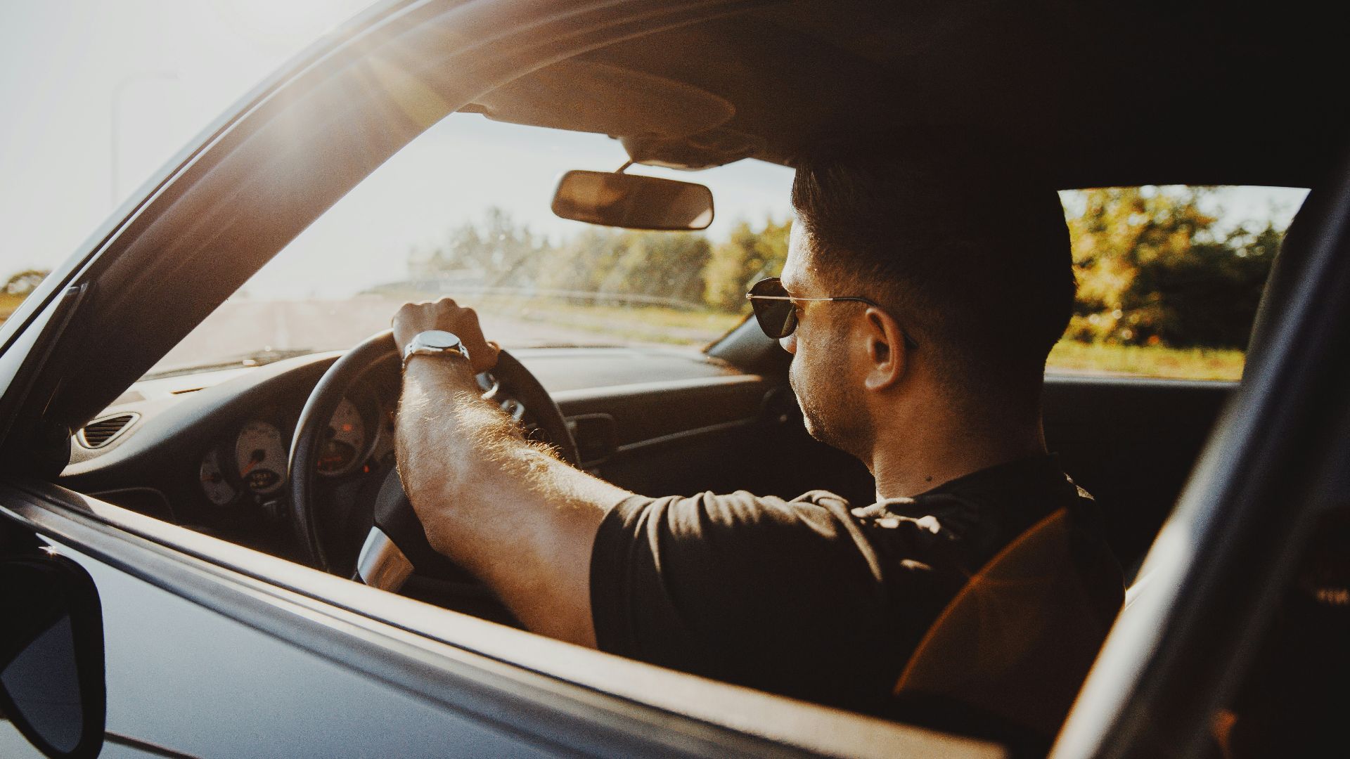 man in black jacket driving car during daytime