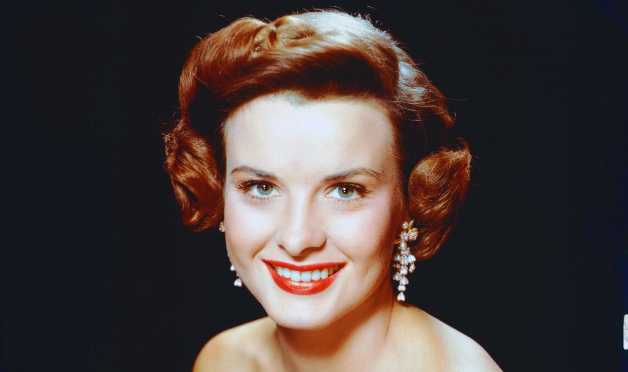 Gettyimages - 120010534, Jean Peters Jean Peters (1926-2000), US actress, wearing a sleeveless blue dress in a studio portrait, against a black background, circa 1955. 