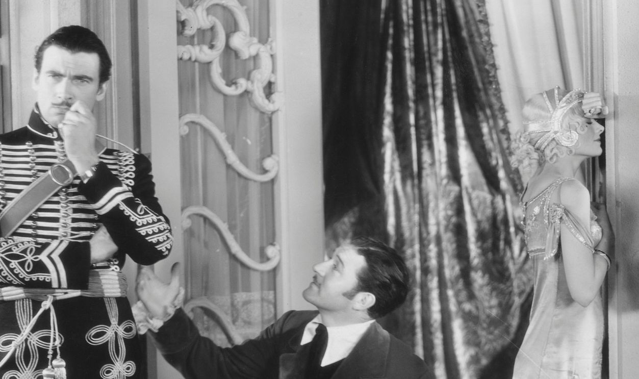 Walter Pidgeon as Colonel Vultow, Allan Prior as Count Adrian Beltrami, Myrna Loy as Sophie, and Lupino Lane as Sprotti in the 1930 film Bride of the Regiment. 