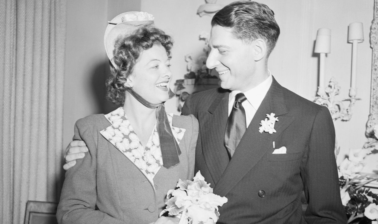 Myrna Loy, beautiful film star, pictured with her husband, John D. Hertz, Jr., after their surprise wedding last night, June 6. The wedding took place at the home of the groom's sister, Mrs. Robert Leylan, in New York. The ceremony was performed by Judge Ferdinand Pecora. The couple have left for a honeymoon trip at an unannounced destination. Mr. Hertz is the son of Mr. and Mrs. John D. Hertz of Chicago.