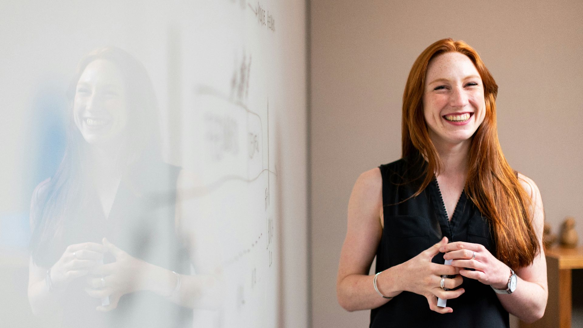 woman in blue tank top standing beside white wall