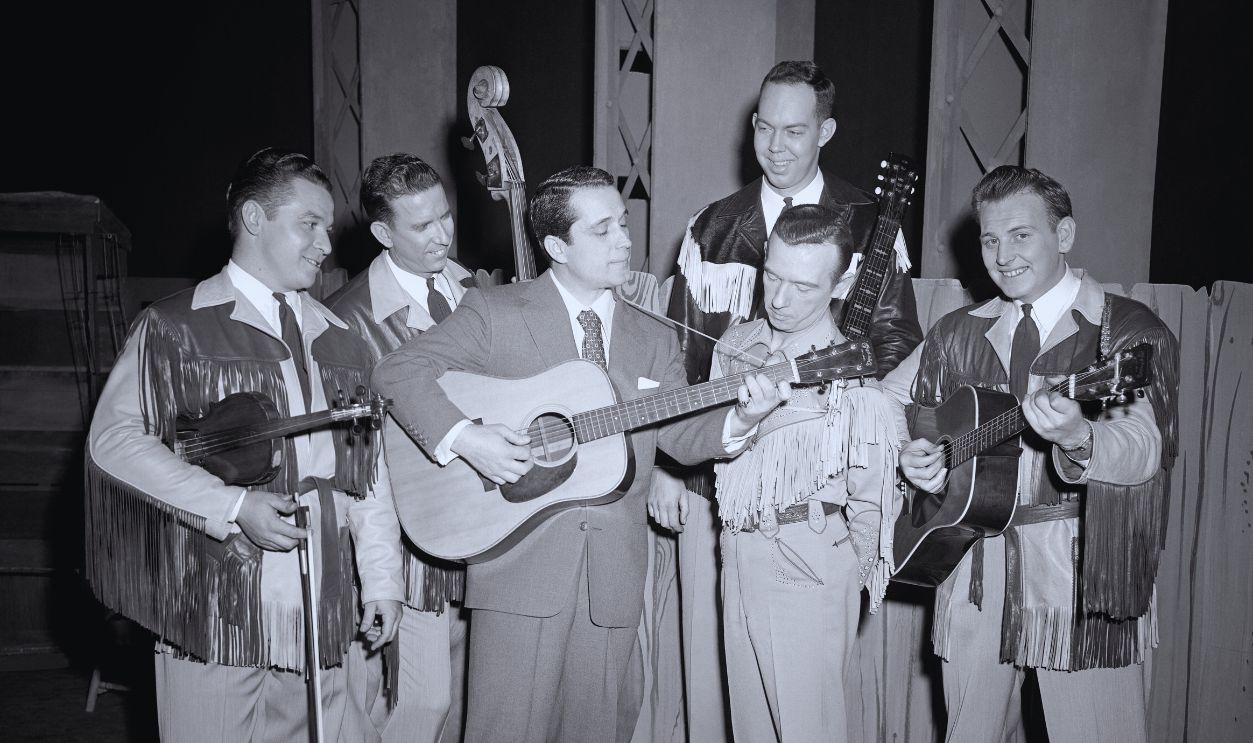 Gettyimages - 2182940264, The Perry Como Show (L-R) American singer and actor Perry Como (1912 - 2001, third from left) plays his guitar as Canadian American guitarist and singer Hank Snow (1914 - 1999, second from right) and members of the Rainbow Ranch Boys watch closely during the filming of 'The Perry Como Show' in New York, New York, February 27, 1952. 