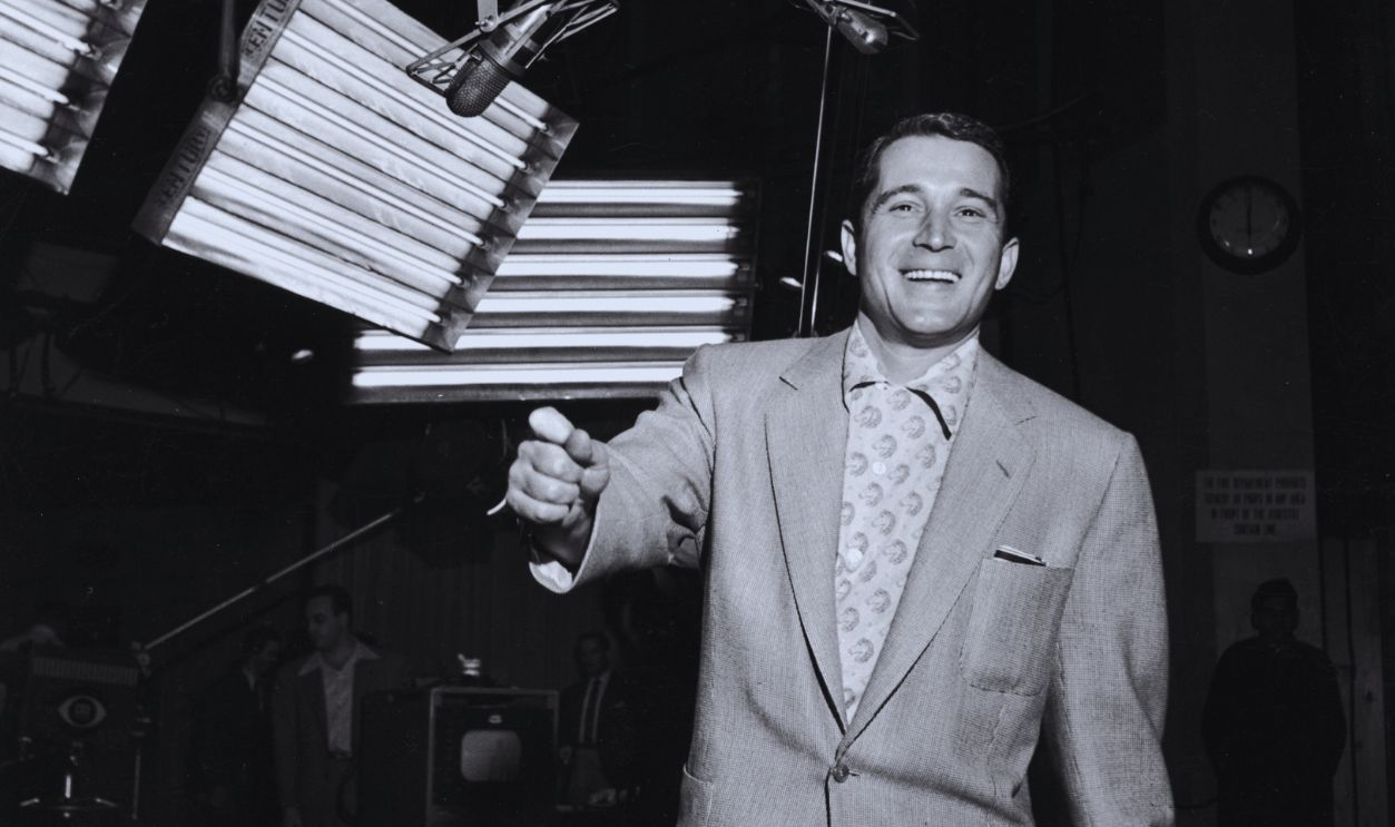 Gettyimages - 3242165, Perry Como March 1953: American pop singer Perry Como (1912-2001) smiles while standing beneath two microphones during a studio recording session. He holds rolled sheet music in one hand. 