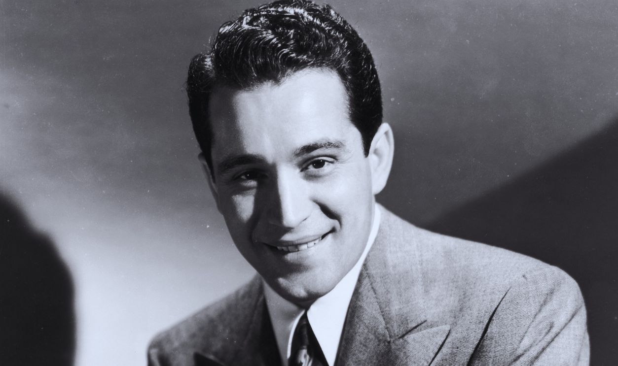 Gettyimages - 3226433, Perry Como circa 1945: Studio portrait of American singer Perry Como (1912 - 2001) wearing a suit and tie, crossing his arms on his lap and smiling.