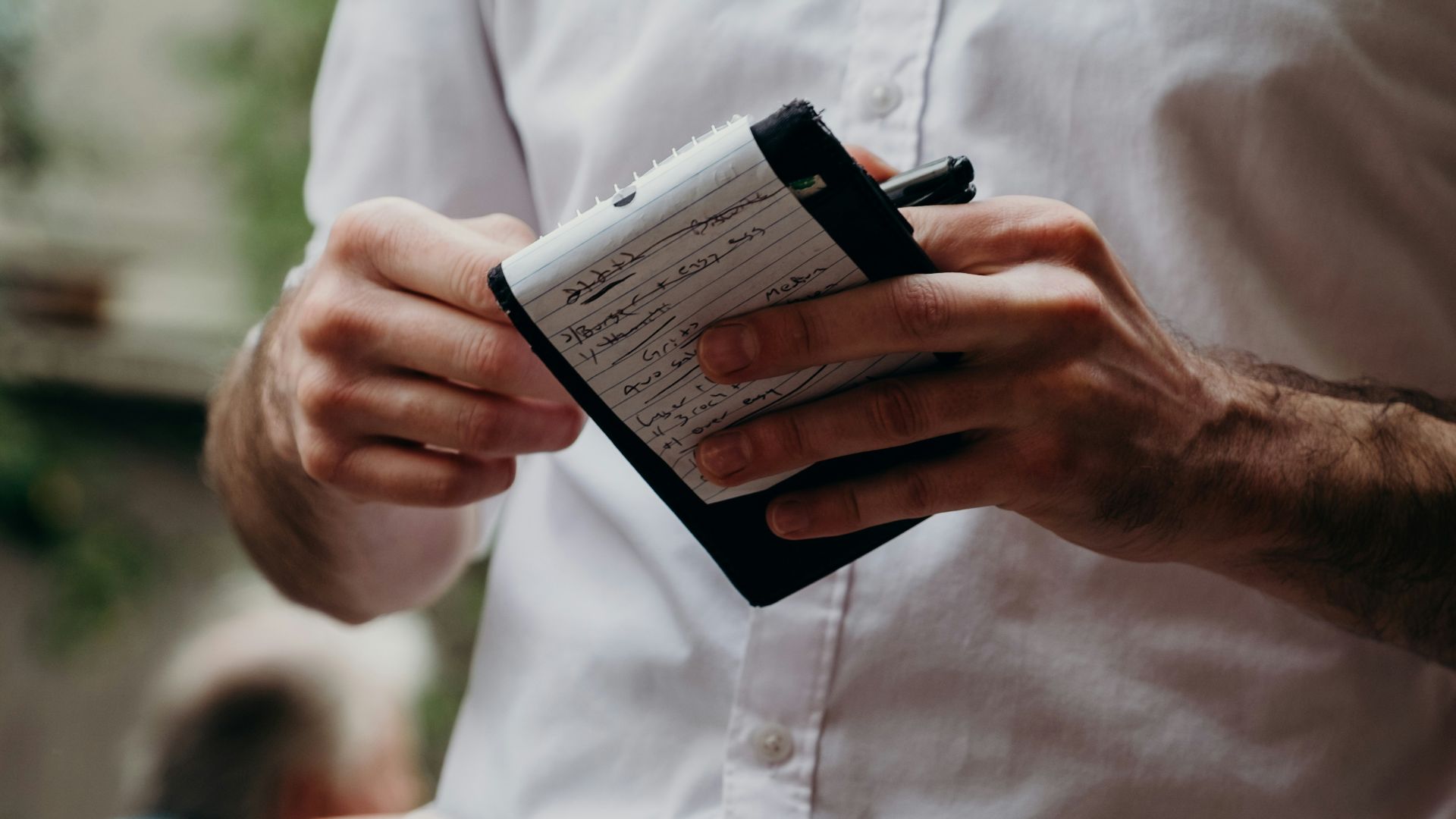 man in white button up shirt holding black and white box