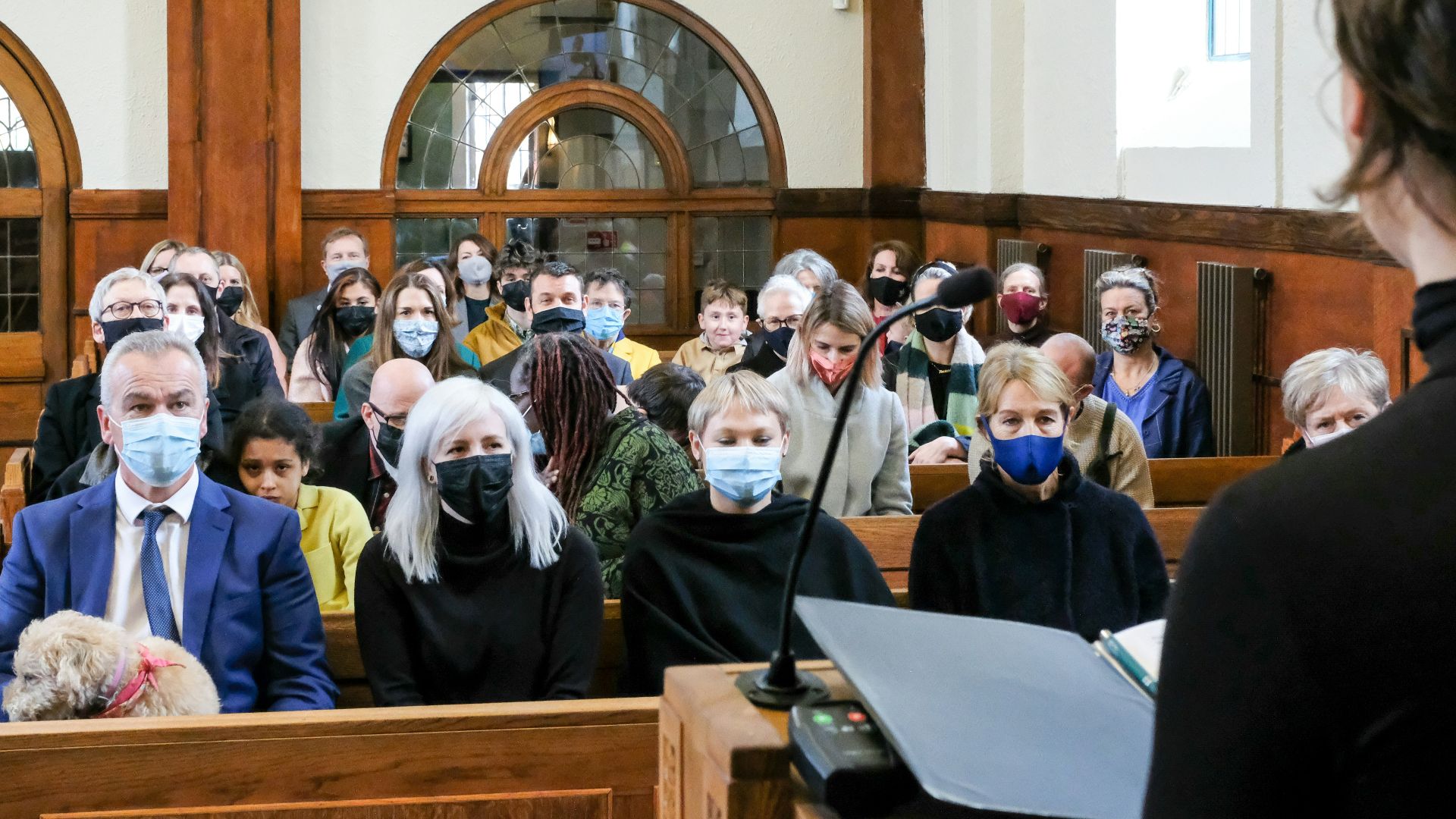 a group of people wearing face masks in a courtroom
